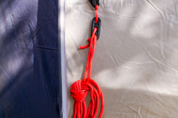 Red Guiide Rope teatly tied up and hanging from a tent