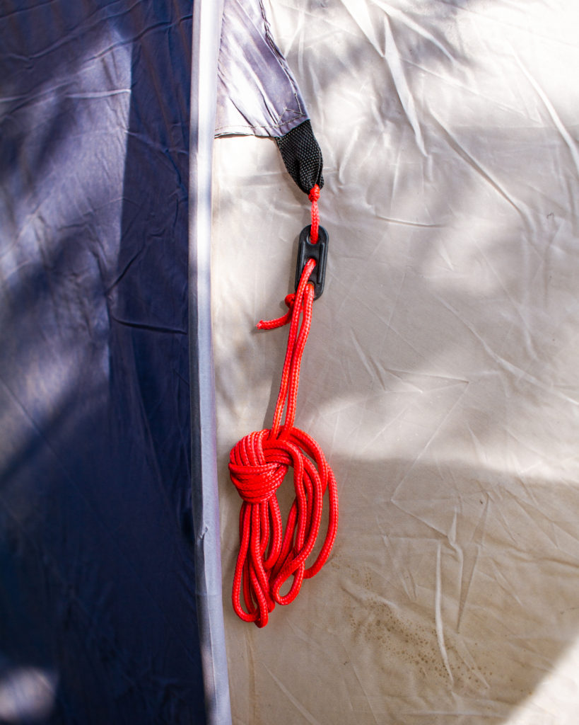Red Guiide Rope teatly tied up and hanging from a tent