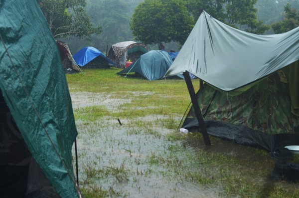 campsite with tents during a heavy downpour and puddles