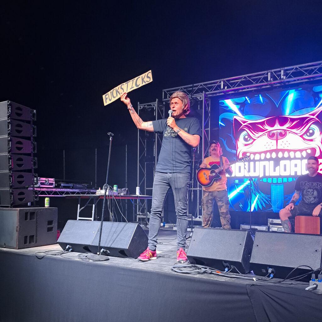 Kunt and the Gang at Download Festival 2023 holding a sign reading Fucksticks